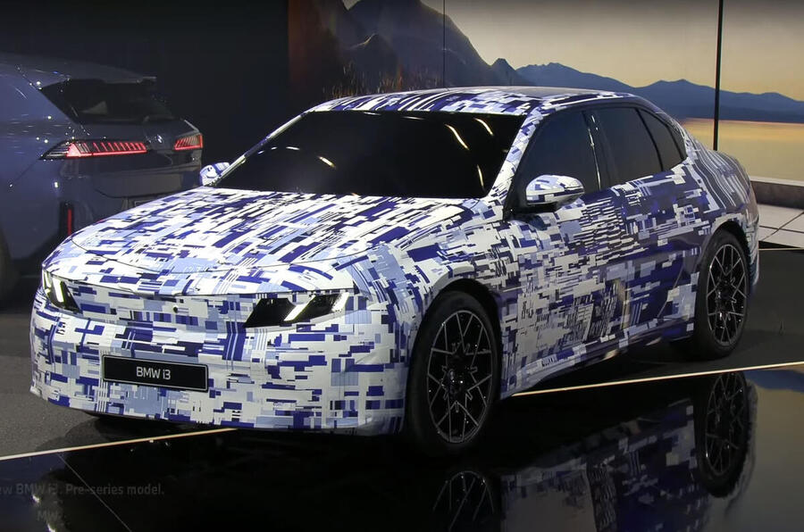 A close-up view of a shiny alloy wheel on a parked car, showcasing intricate spokes and a well-treaded tire.