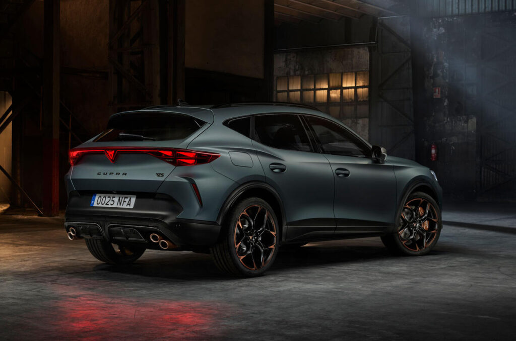 A red SUV parked on a city street, reflecting the urban landscape.
