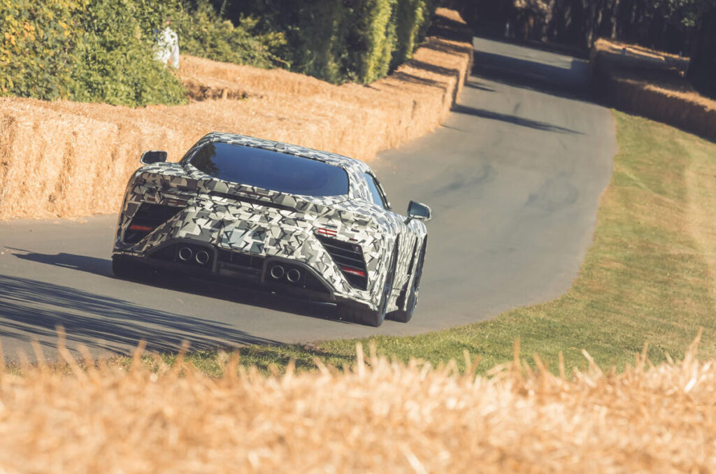 A person driving a red car on a sunny day.