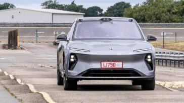 A close-up view of a car's bumper featuring a license plate and wheels, illustrating elements of transportation and vehicle machinery.